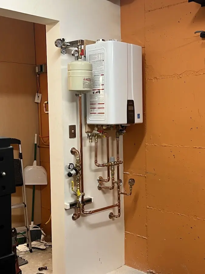 Plumbing technician inspecting water heater connections in Middlesex